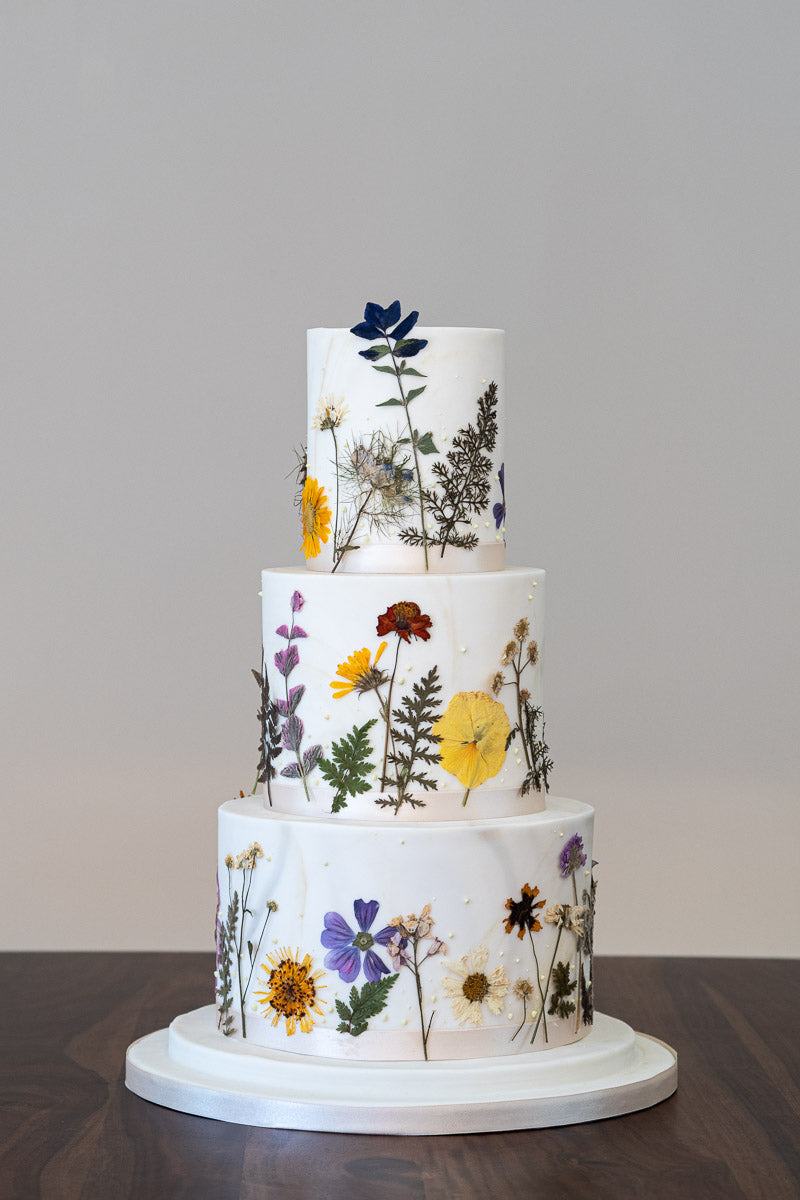 Nature influenced, pressed edible flower wedding cake. Think wild flower meadows and hazy summer days.