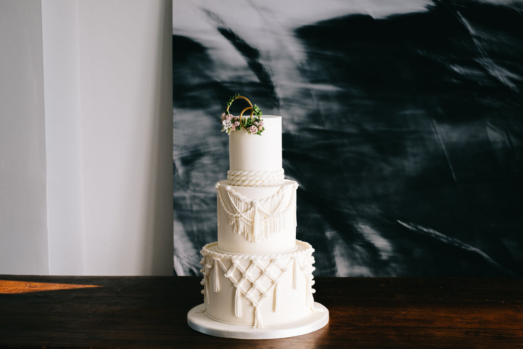 Macrame detail wedding cake against dark background in Lancashire.   
