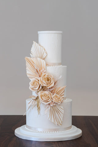 Wedding cake with a warm neutral colour palette and a touch of 1920's art deco glamour, inspired by the trend for combining  delicate fresh blooms with architectural dried flowers.