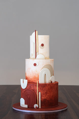 Abstract wedding cake inspired by modern geometric abstract art of the mid century in terracotta, white and gold.