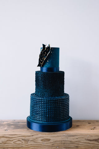Great value contemorary navy blue textured three tier wedding cake with abstract voile edged in edible gold leaf. By Saddleworth based Union Cakes