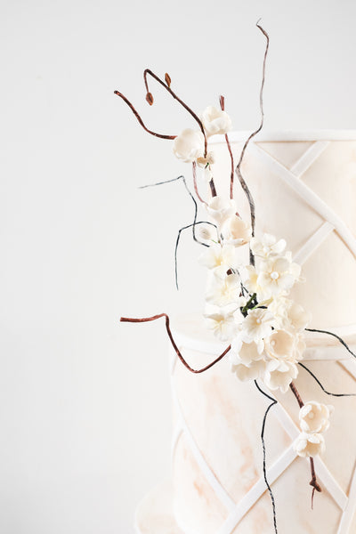 Delicate sugar blossoms adorn a contemporary coastal inspired wedding cake
