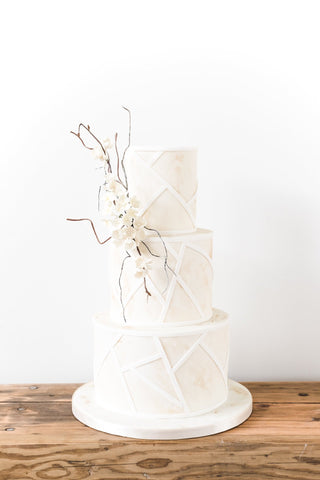 Modern wedding cake with a coastal, sun-bleached design and delicate sugar flowers